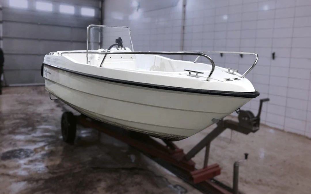 Vit motorbåt på trailer i hallen