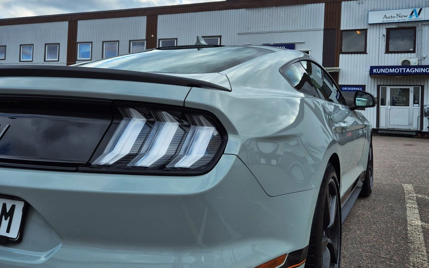 Ljus Ford Mustang efter rekond utanför hallen